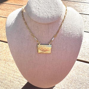 Collana con ciondolo a forma di busta da lavoro Art Déco con dettagli in zirconia cubica a baguette e catena a graffetta dorata
