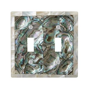 May include: A decorative double light switch cover with a mosaic design. The cover features iridescent abalone shell pieces in shades of blue, green, and purple. The border is made of small, square, off-white tiles. Includes two light switch openings and silver screws.