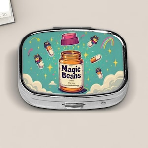 May include: A silver pill case with a whimsical design. The case features a teal background with cartoon pills, a rainbow, and a jar labeled "Magic Beans." The jar has a pink lid and the text "Caution: May cause functional adulthood."