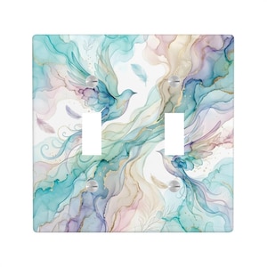 May include: A double light switch wall plate featuring an abstract watercolor design with flowing teal, purple, and gold ink-like swirls. Two birds are depicted in flight amidst scattered feathers and delicate line-drawn botanical accents.