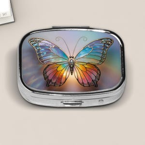 Pastel Rainbow Butterfly Pill Box – Stained Glass Style Pocket Case with Soft Glow Background and Gem Details