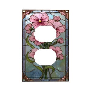 May include: A decorative light switch cover featuring a stained-glass design. The cover showcases a bouquet of pink flowers with green stems and leaves against a blue and green background. The border is a dark brown color.