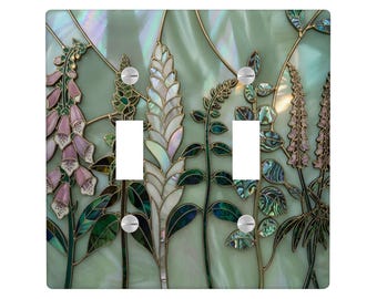 May include: A double light switch plate featuring a botanical mosaic design with iridescent abalone shell inlays. The artwork displays pink foxgloves, white wheat stalks, and green foliage against a pale green background with gold outlines.