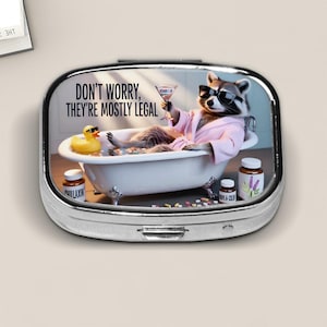Funny Raccoon Pill Box – “Don’t Worry, They’re Mostly Legal” Bathtub Humor Case – Quirky Medicine Holder Gift for Relaxation Lovers