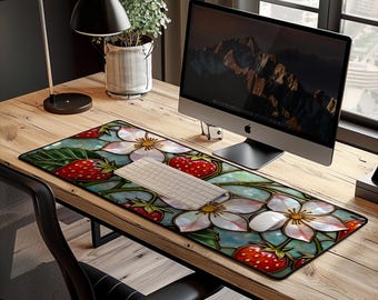 May include: A rectangular desk mouse pad featuring a stained-glass design with strawberries and white flowers. The pad is on a wooden desk with a computer, keyboard, and mouse. The design has red, white, and green elements.