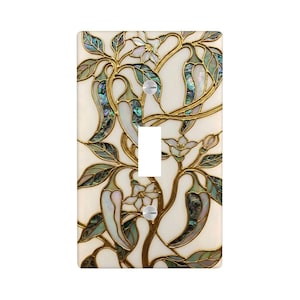 May include: Decorative light switch cover featuring a botanical design. The cover has a cream-colored background with a pattern of chili peppers, leaves, and flowers in shades of green, gold, and iridescent abalone shell. The switch is white.
