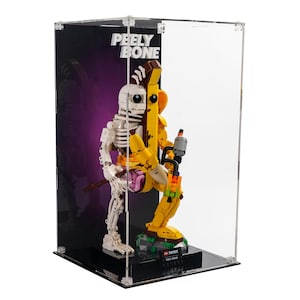 May include: A clear acrylic display case containing a LEGO Fortnite Peely Bone figure. The figure is a yellow banana with a skeleton inside. The figure is holding a gun and has a banana peel on its foot.