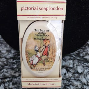 Puede incluir: Una caja rectangular de jabón Pictorial Soap London con una pastilla de jabón ovalada que muestra a Jemima Puddle-Duck y un zorro. El texto dice The Tale of Jemima Puddle-Duck by Beatrix Potter y But as to a nest there is no difficulty.