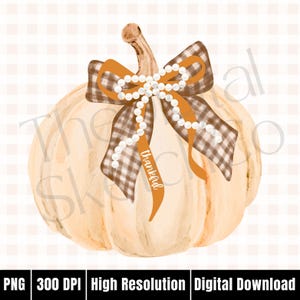 May include: A watercolour illustration of a cream-coloured pumpkin adorned with a brown and white plaid bow and an orange ribbon bearing the word "thankful". A string of white pearls decorates the bow. The pumpkin has a brown stem.