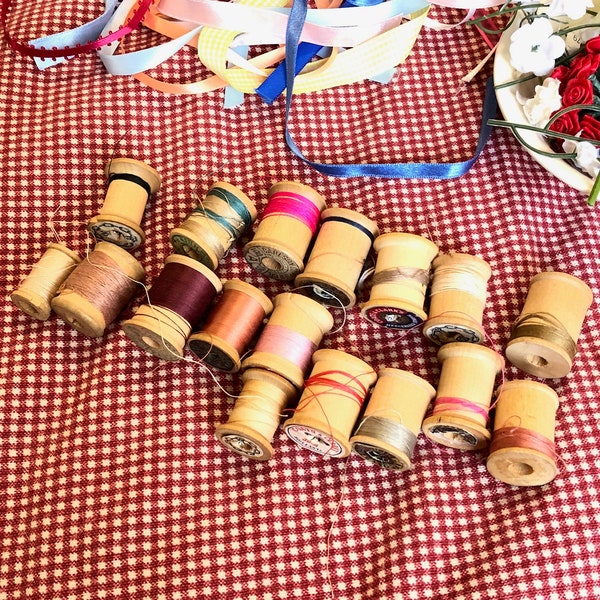 collection of vintage wooden thread spools with bits of thread