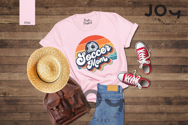 May include: A pink t-shirt with a retro "Soccer Mom" design and a soccer ball graphic. The image also shows red trainers, blue jeans, a straw hat, and a brown backpack.