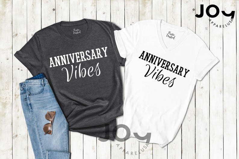 May include: Two t-shirts with the text 'Anniversary Vibes' in black on a white t-shirt and white on a gray t-shirt.
