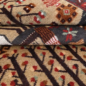 Pu&ograve; includere: Primo piano di un tappeto marrone e nero con un motivo ripetitivo di alberi e fiori. Il tappeto ha una texture morbida e soffice.