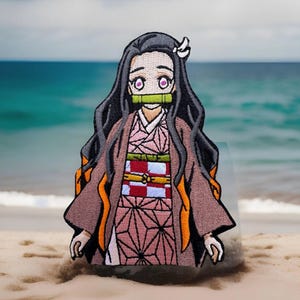 May include: Embroidered patch featuring a character from the anime Demon Slayer. The character has long black hair, pink eyes, and is wearing a pink and white kimono with a green mouth guard.