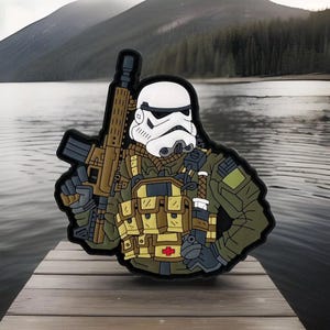 May include: A white and black cartoon illustration of a Stormtrooper wearing a green military uniform and carrying a rifle. The Stormtrooper is wearing a medical patch on their chest.
