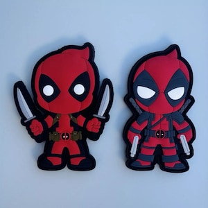 May include: Two red and black cartoon Deadpool patches with white eyes. One patch has a red and black suit with two silver knives. The other patch has a red and black suit with two silver pistols.