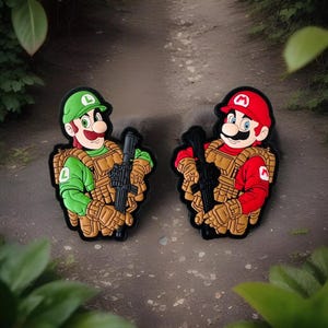 May include: Two embroidered patches featuring Mario and Luigi characters from the Super Mario Bros. video game series. The patches depict the characters in military gear, holding rifles and wearing tactical vests. The patches are green, red, brown, and black.