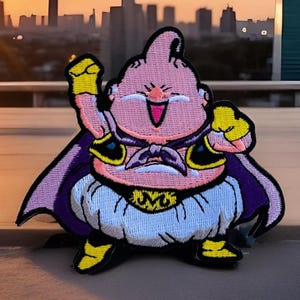 May include: An embroidered patch of a pink cartoon character with a purple cape and a yellow belt. The character is smiling and has a mischievous expression. The patch is perfect for adding a touch of fun to any project.