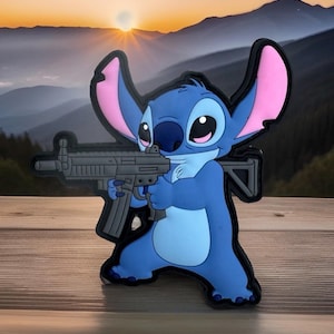 May include: A blue cartoon character patch with large ears and a gray weapon. The character is holding the weapon with a determined expression. The background features a sunset over a mountain range.