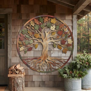 May include: A circular metal wall art piece featuring a tree with exposed roots and branches adorned with multicolored leaves in shades of red, orange, yellow, and green. The frame is a thin metal ring with a gradient finish of copper and bronze tones.