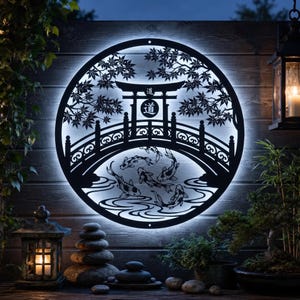 Könnte beinhalten: Ein kreisförmiges Wandkunstobjekt aus schwarzem Metall mit einer hinterleuchteten Silhouette einer japanischen Brücke, einem Torii-Tor mit dem Kanji-Zeichen für Weg und schwimmenden Koi-Fischen. Das Motiv ist von Ahornblättern umrahmt.