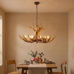 May include: A chandelier constructed from light brown, textured deer antlers featuring six upward-facing light bulbs. The fixture is suspended from the ceiling by a dark metal chain and is positioned above a wooden dining table.