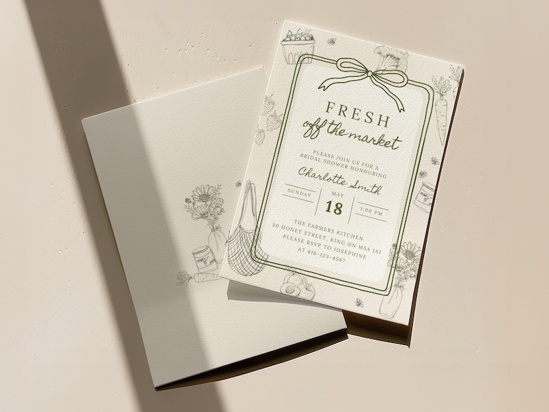 May include: An invitation card with the text "FRESH off the market" and details for a bridal shower. The card features illustrations of vegetables, flowers, and a shopping bag. The invitation is on a light beige background.