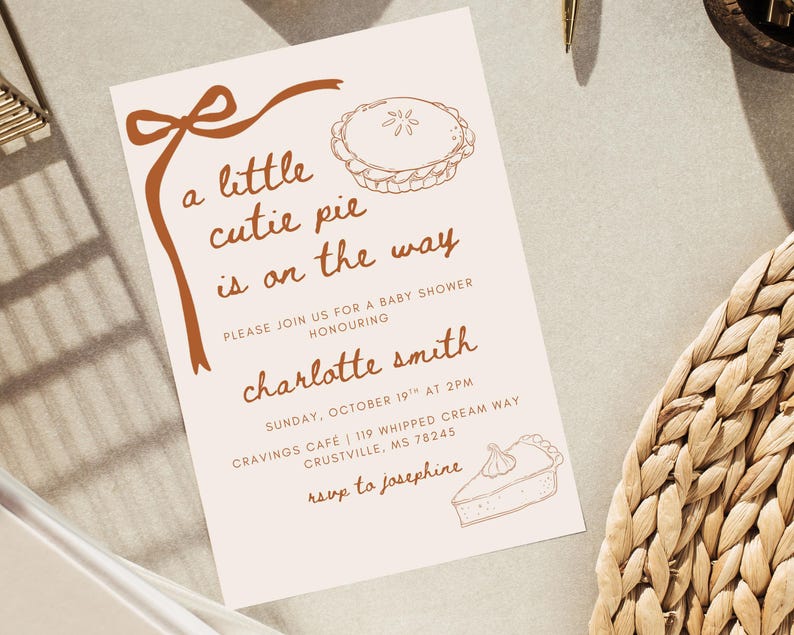 May include: A baby shower invitation with a light beige background and brown text and illustrations. The text reads "a little cutie pie is on the way" and includes details for the event honoring Charlotte Smith.
