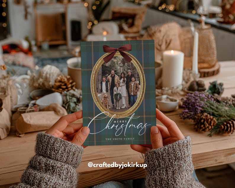 May include: A Christmas card with a family photo inside an oval frame, adorned with a burgundy bow. The card features a green and blue plaid pattern and the words "Merry Christmas" in elegant script. The family name is also included.