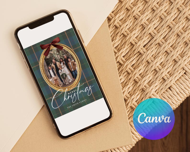 May include: A smartphone displays a Christmas card design. The card features a family photo within a gold oval frame, set against a green and blue plaid background. A red bow adorns the top, with the words "Merry Christmas" and "The Smith Family" in elegant script.