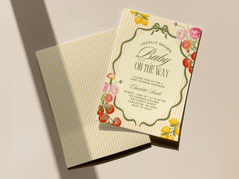 May include: Baby shower invitation with the text "Locally Grown Baby On The Way." The invitation has a cream background with vertical stripes and is decorated with watercolor lemons, tomatoes, and flowers. The invitation includes the date, time, and location.