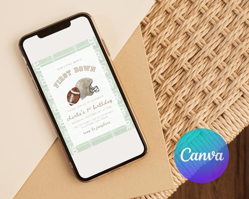 May include: A smartphone screen shows a digital invitation for a first birthday celebration. The invitation design includes a football, a helmet, and the words "First Down." The text reads "Our Little Man's" and "Charlie's 1st Birthday." The background is light green.