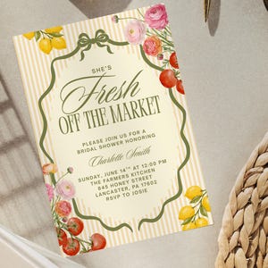 May include: A bridal shower invitation with a vintage design. The invitation features the text "She's Fresh Off The Market" in elegant script, surrounded by floral and fruit illustrations. The background has vertical stripes.