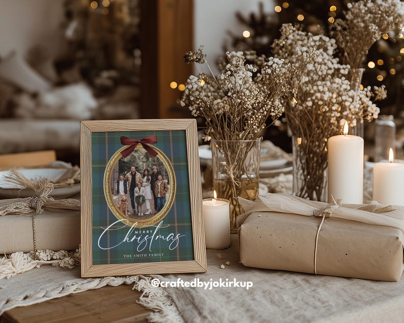 May include: A framed family photo with a Christmas theme. The photo is in an oval shape, surrounded by a gold border and a red bow. The words "Merry Christmas" are written in elegant script below the photo. The frame is made of light wood.