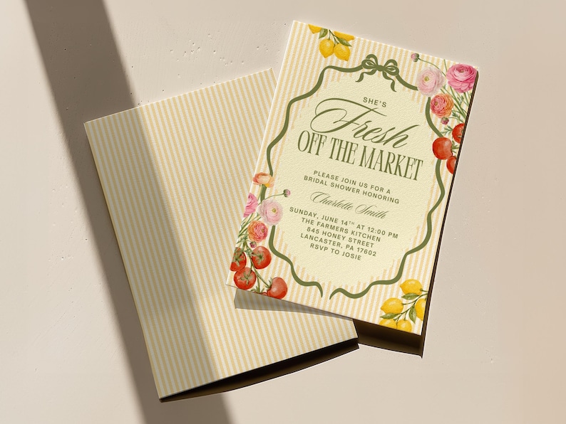 May include: A bridal shower invitation with a vintage design. The invitation features the text "She's Fresh Off The Market" with floral and fruit illustrations. The background is a light cream color with vertical stripes.
