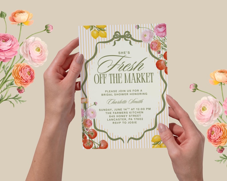 May include: A bridal shower invitation with the text "She's Fresh Off The Market" in elegant script. The invitation is held by hands and decorated with floral and fruit illustrations, including lemons, tomatoes, and roses.