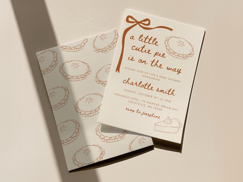 May include: Baby shower invitation with a pie theme. The invitation features the text "a little cutie pie is on the way" in brown script. The invitation also includes the name "Charlotte Smith" and event details.
