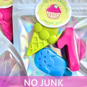 May include: A clear holographic pouch containing three shaped crayons: a lime green ice cream cone, a bright blue popsicle, and a hot pink number one. A round sticker on the front features a pink cupcake illustration and the text You're the sweetest Thank you.
