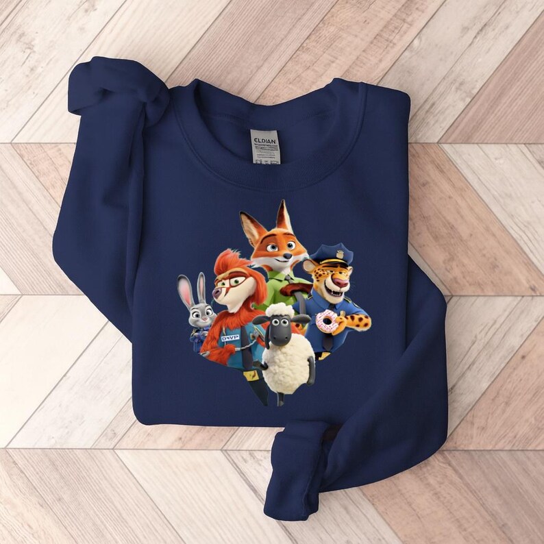 Op de afbeelding: Marineblauwe sweatshirt met een kleurrijke afbeelding van personages uit de animatiefilm Zootopia. Het ontwerp bevat een vos, een konijn, een schaap, een cheetah en andere personages. De sweatshirt is gemaakt van een zacht materiaal.