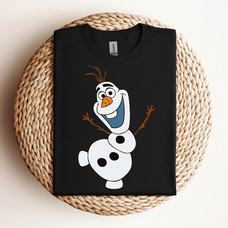 Pode incluir: Camiseta preta com um boneco de neve de desenho animado branco e laranja com um nariz de cenoura e olhos azuis. O boneco de neve est&aacute; sorrindo e tem os bra&ccedil;os estendidos.
