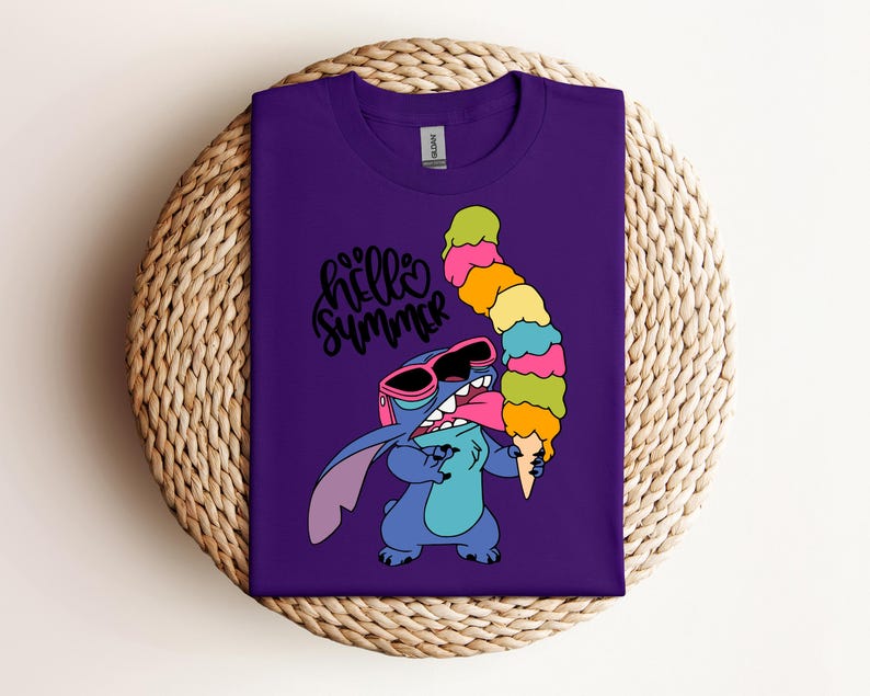 May include: A purple t-shirt featuring a cartoon character wearing sunglasses and holding a large, colorful ice cream cone. The words "hello summer" are written in a cursive font above the character. The shirt is displayed on a woven surface.
