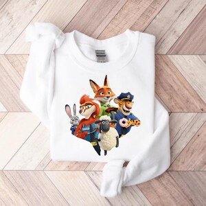 Op de afbeelding: Witte sweatshirt met een kleurrijke afbeelding van geanimeerde dierenfiguren. Het ontwerp bevat een vos, een konijn, een schaap, een cheetah en andere karakters. De sweatshirt is gemaakt van een zacht materiaal en is geschikt voor vrijetijdskleding.