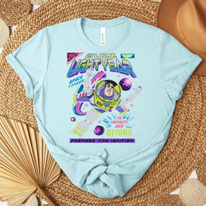 Puede incluir: Camiseta azul claro con un dise&ntilde;o de Buzz Lightyear de Toy Story. El dise&ntilde;o incluye el texto "Buzz Lightyear" y "To Infinity and Beyond". La camiseta tiene cuello redondo y mangas cortas.