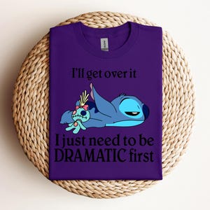 Puede incluir: Camiseta morada con un dibujo animado de Stitch y Angel de Lilo & Stitch. El texto dice "I'll get over it I just need to be DRAMATIC first."