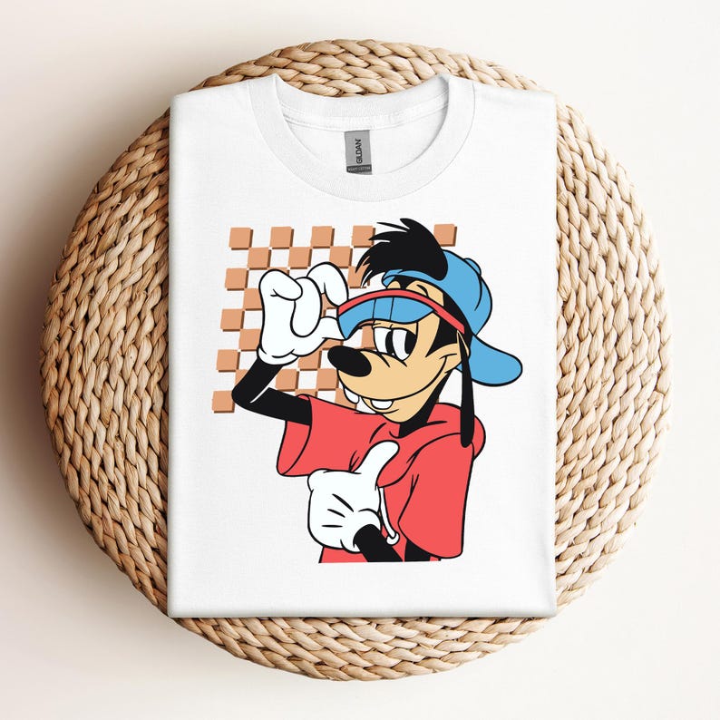 May include: White t-shirt with a cartoon image of Goofy wearing a red shirt, blue hat, and sunglasses. The background is a checkered pattern.