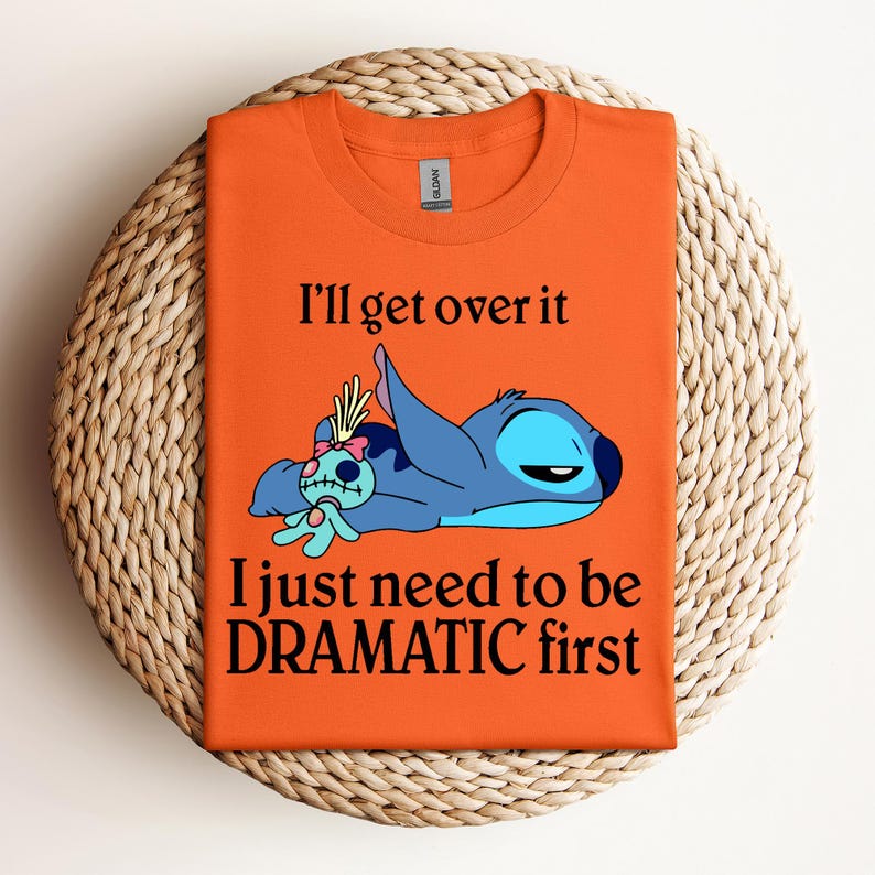 Puede incluir: Camiseta naranja con un personaje azul Stitch de Lilo & Stitch. El texto en la camiseta dice "I'll get over it I just need to be DRAMATIC first."