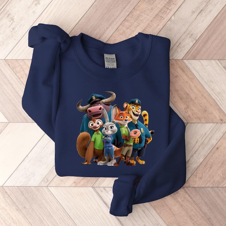 Puede incluir: Una sudadera azul marino con un gr&aacute;fico colorido de personajes de la pel&iacute;cula animada Zootr&oacute;polis. El dise&ntilde;o incluye una ardilla, un conejo, un zorro, un tigre y un b&uacute;falo, todos con uniformes de polic&iacute;a. La sudadera es de material suave.