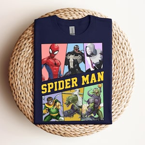 Pode incluir: Camiseta azul marinho com um gr&aacute;fico colorido do Homem-Aranha e outros personagens. O design inclui Homem-Aranha, Venom, Spider-Gwen, Doutor Octopus, Lagarto e Duende Verde. As palavras "SPIDER MAN" s&atilde;o impressas em amarelo.