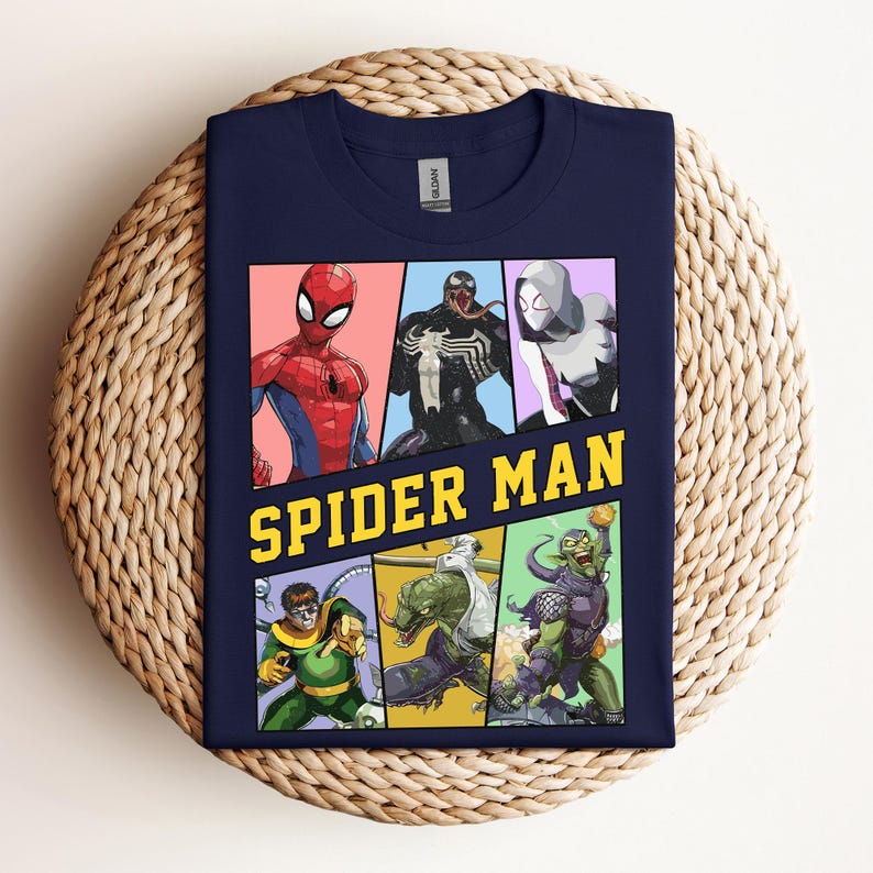 Pode incluir: Camiseta azul marinho com um gr&aacute;fico colorido do Homem-Aranha e outros personagens. O design inclui Homem-Aranha, Venom, Spider-Gwen, Doutor Octopus, Lagarto e Duende Verde. As palavras "SPIDER MAN" s&atilde;o impressas em amarelo.