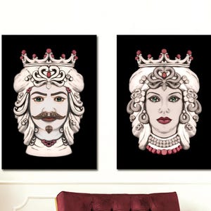 May include: Two framed wall art pieces featuring stylized portraits of a king and queen with crowns, set against a black background. The king has a mustache, and both figures have ornate details. The art is displayed above a burgundy velvet chair.